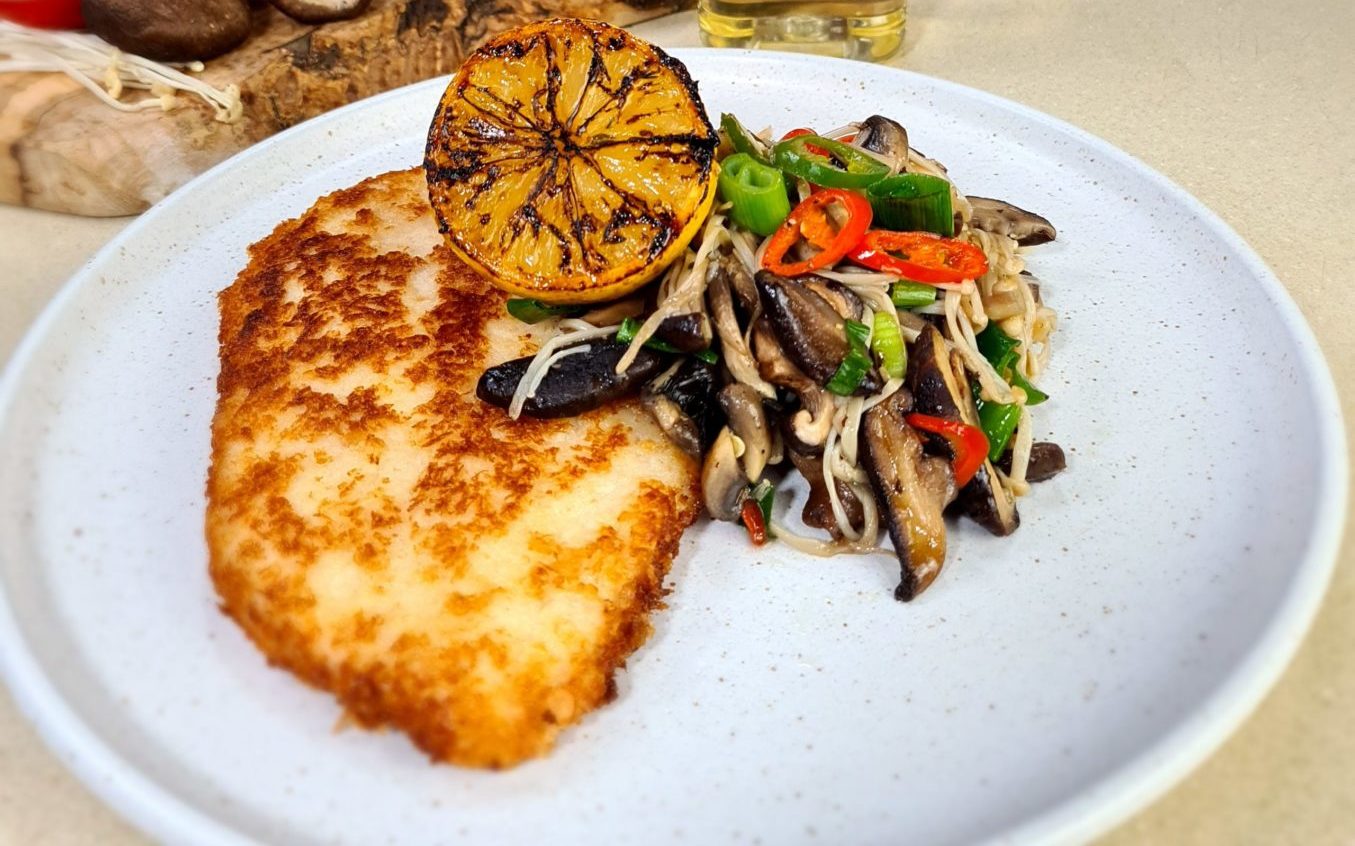 Chicken schnitzel with stir fry vegetables on a plate