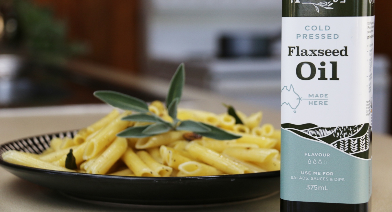 Bottle of Plenty Flaxseed Oil with a plate of Sage and Garlic Penne Pasta