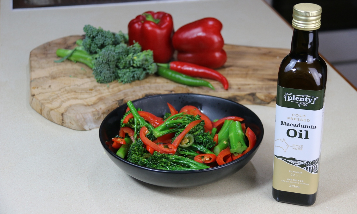 Bottle of Plenty Macadamia Oil with a plate of Sautéed Broccolini and Capsicum